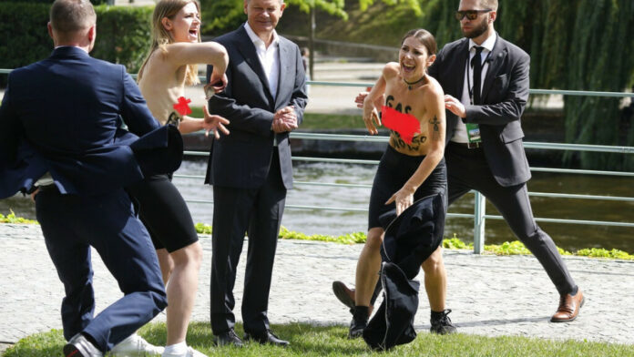 Γερμανία: Απρόοπτο για τον Σολτς με «επίθεση» από γυμνόστηθες ακτιβίστριες – Δεν φάνηκε να ενοχλείται